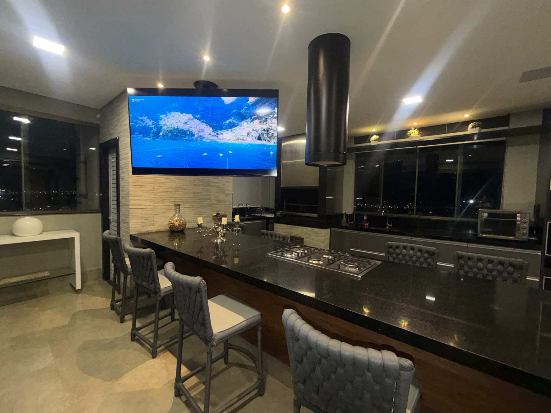 Cozinha integrada com televisão suspensa sobre a ilha