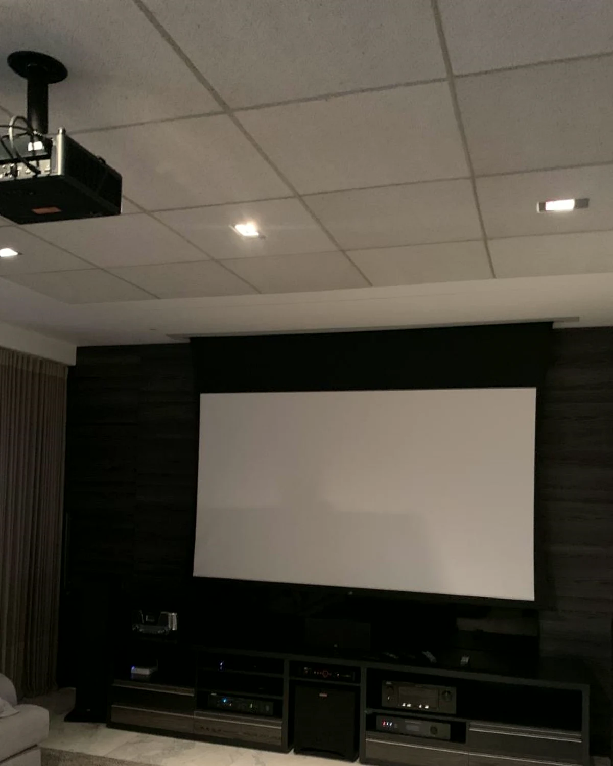 Cinema residencial com projetor, tela de projeção, forro acústico e equipamentos