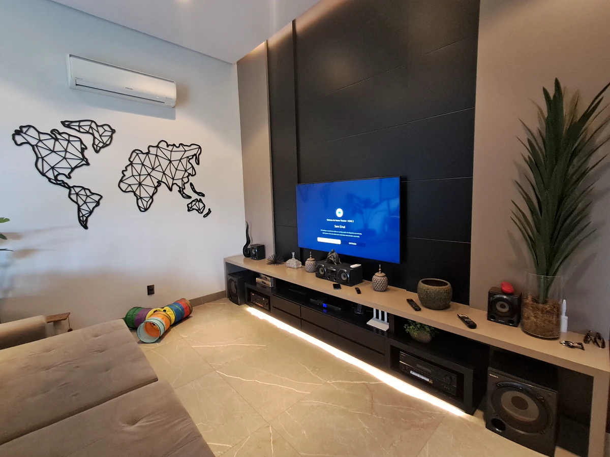 Painel audiovisual com televisão, caixa central, eletrônicos e caixas laterais