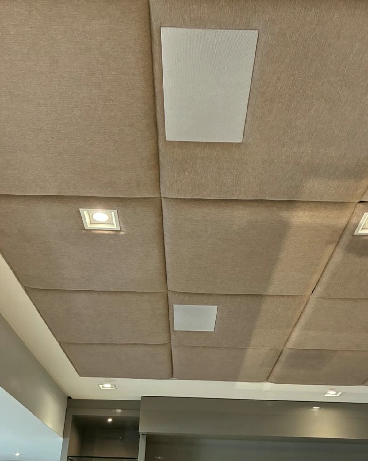 Detalhe de teto com tratamento acústico e caixas de áudio integradas